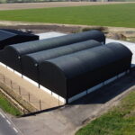Triple apex barn after refurbishment with new steel frame and new black cladding and roof.