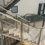 Curved external staircase with mesh filled decorative railings