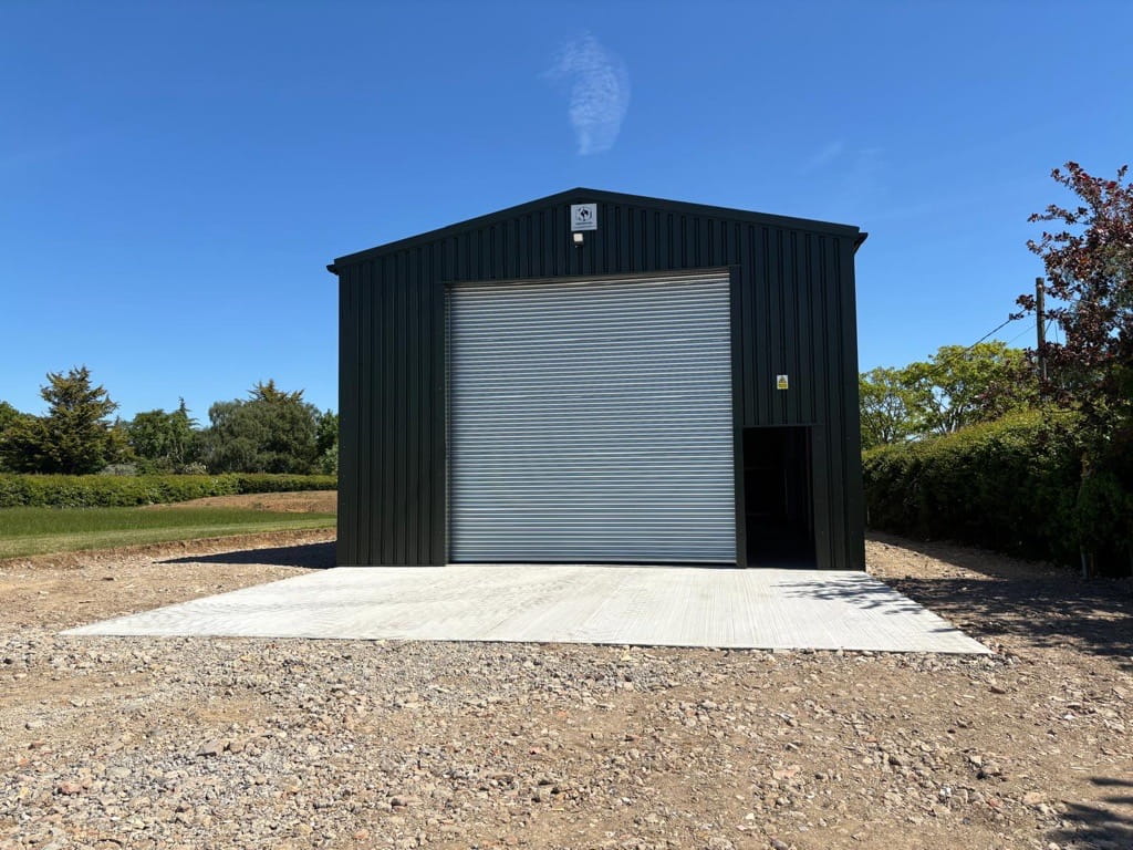 An agricultural workshop with a single roller shutter door and a single personnel door to the front gable end