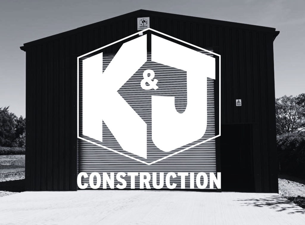 K & J construction ltd logo over a black and white background of a steel portal frame building